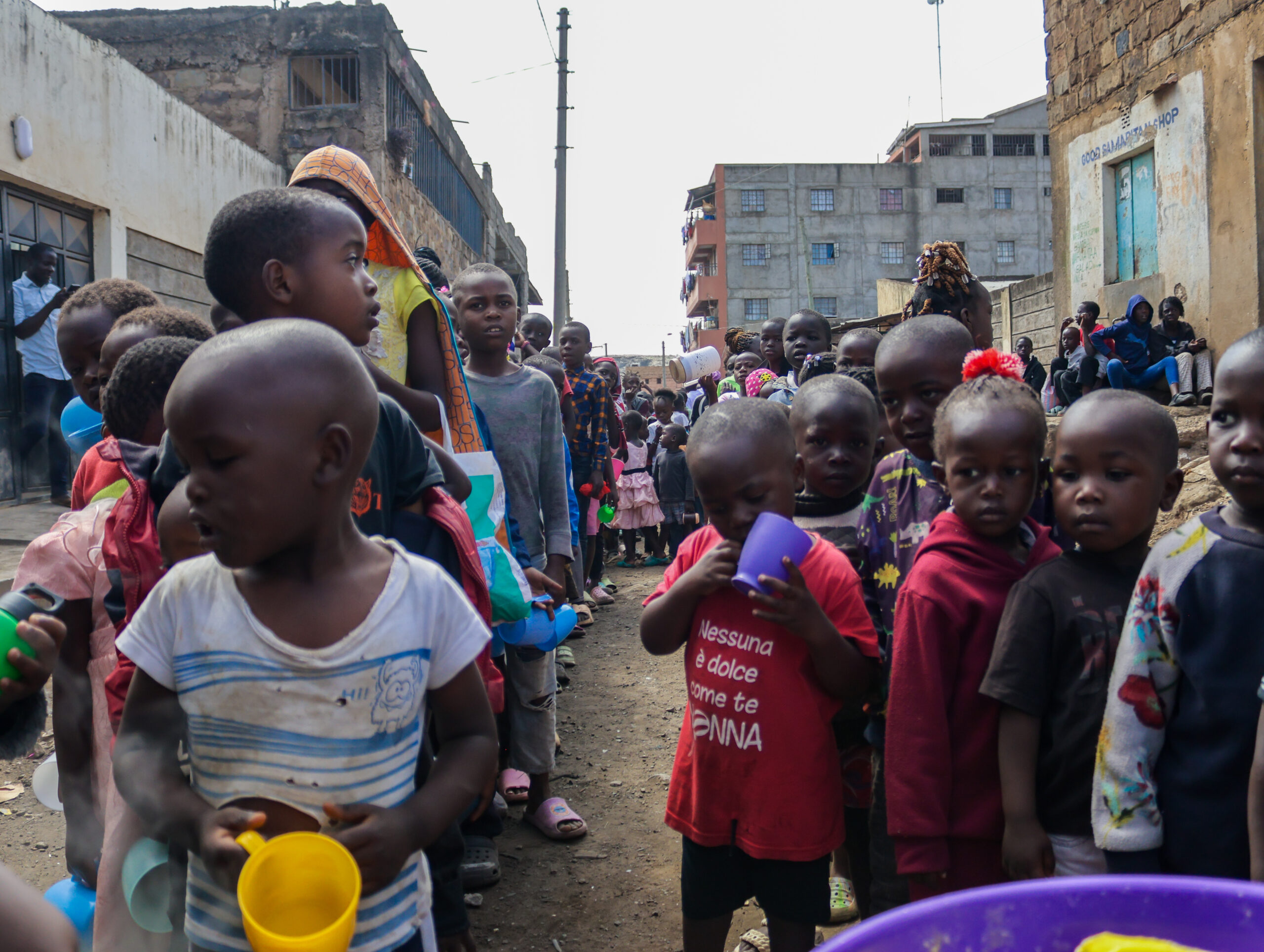 Children outside the library of Teds Community Hub queuing for the Saturday Porridge Feeding Program. 